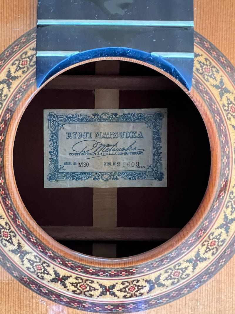 The paper label inside a Ryoji Matsuoka guitar, seen through the soundhole, printed in blue on cream with an ornate border and reading model M30 and serial number 21603